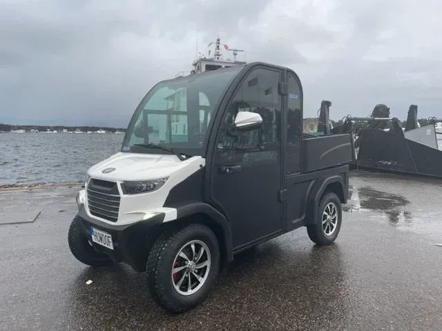 Italcar elfordon med hytt och flak vid en kaj