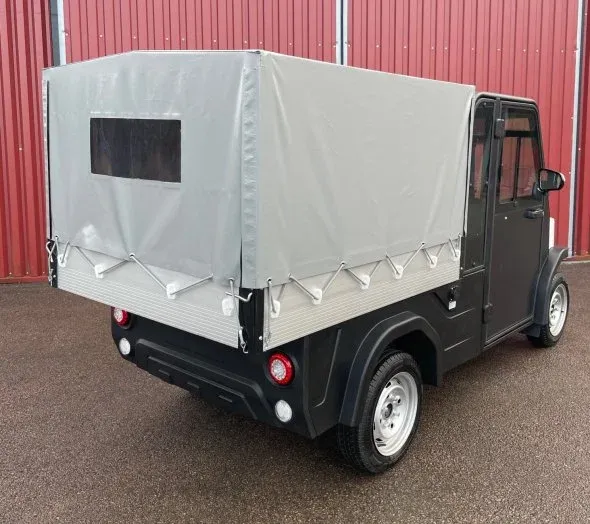 Svart elfordon med kapell över flaket, bakifrån