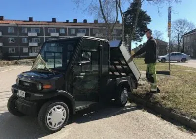 Arbetsfordon med tippflak och en person vid flaket