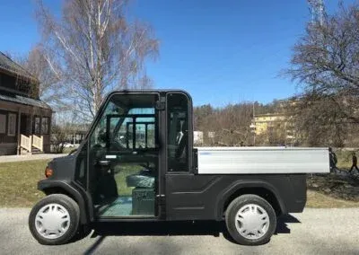 Arbetsfordon med hytt och aluminiumflak, från sidan