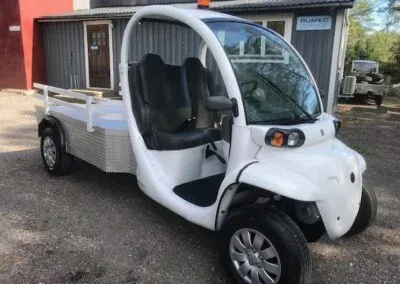 Vitt GEM elfordon med flak och varningsljus, framifrån