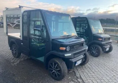 Två arbetsfordon med hytt, det främre med skåp